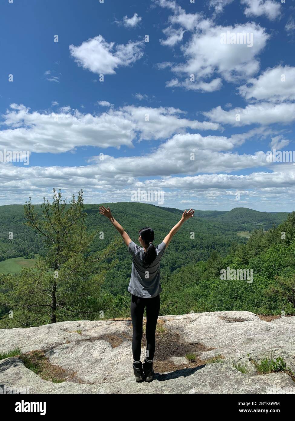 Une femme randonneur qui célèbre au sommet d'une montagne et d'une vue sur le paysage à Falls Village Connecticut sur le sentier bleu mohawk. Banque D'Images