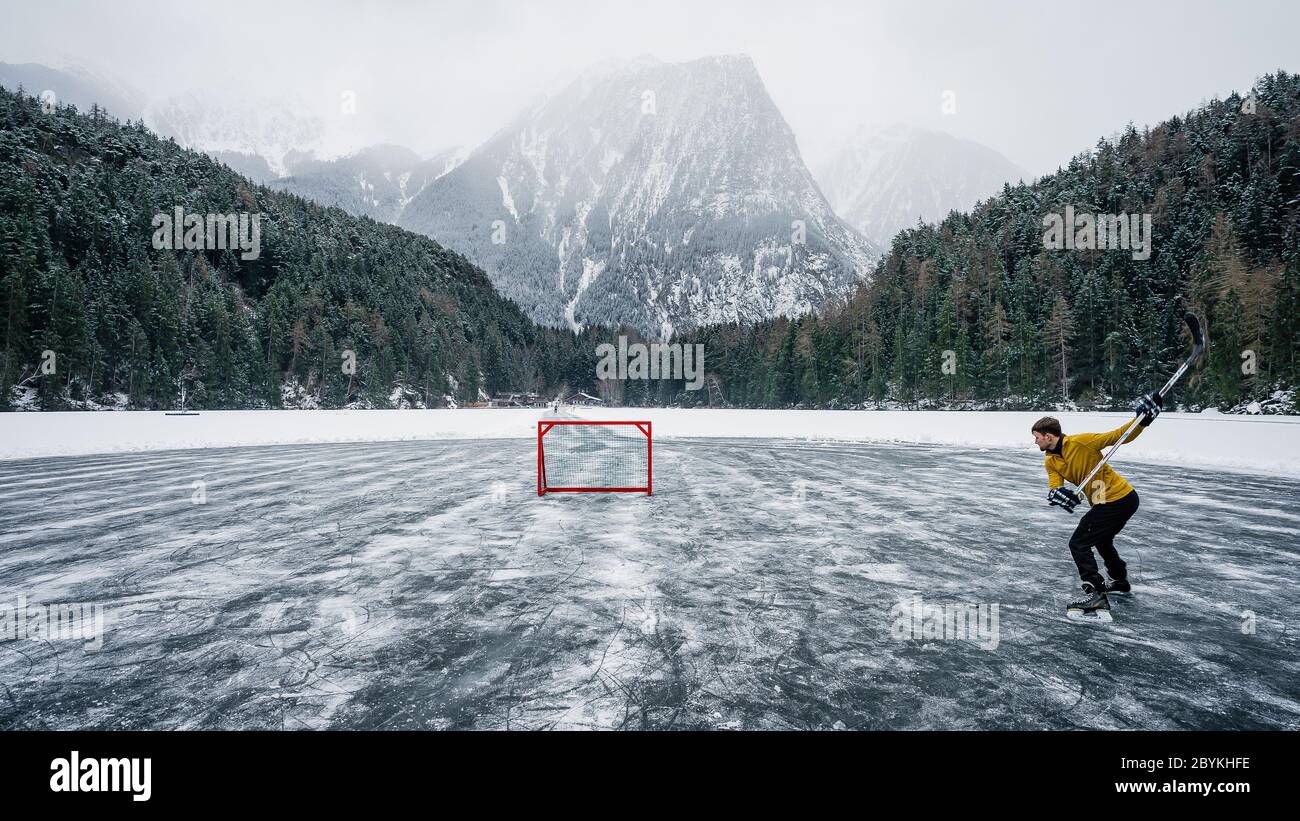 Le joueur de hockey sur glace tire et marque. Joueur sur un étang gelé. Patins sur les pieds du joueur pendant le hockey sur glace. Joueur de hockey pratiquant sur un étang gelé Banque D'Images