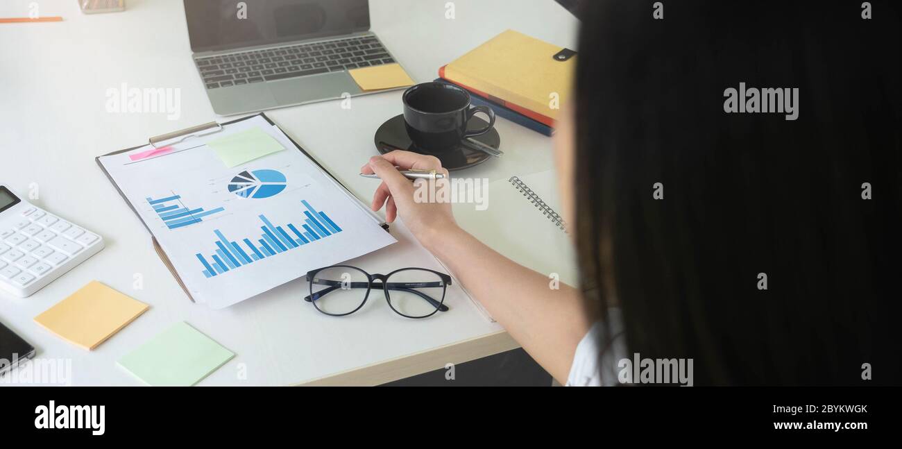 Femme d'affaires utilisant la calculatrice pour faire des finances mathématiques sur le bureau en bois dans le bureau et les affaires de travail, la fiscalité, la comptabilité, les statistiques et l'analytique Banque D'Images