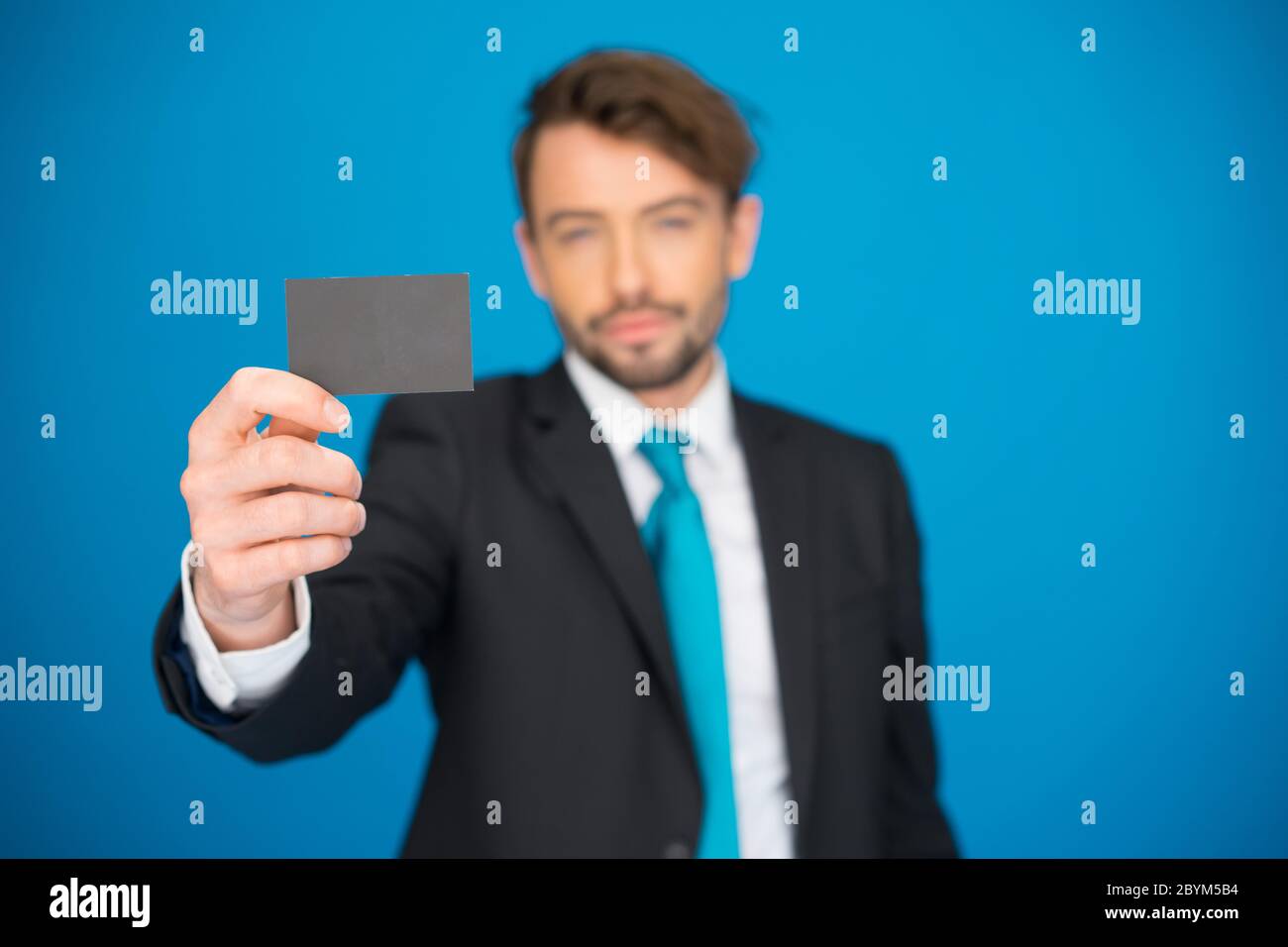 Handsome businessman showing blank business card Banque D'Images