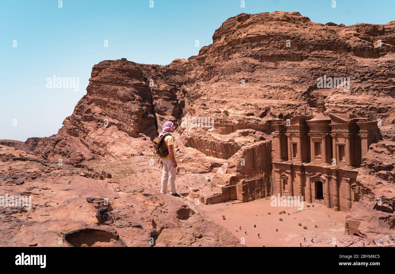 Grimpeur avec sac à dos de randonnée aller à la montagne. Randonneurs dans le monastère ou ad Deir, et le bâtiment monumental sculpté dans la roche de Petra Jordanie Banque D'Images