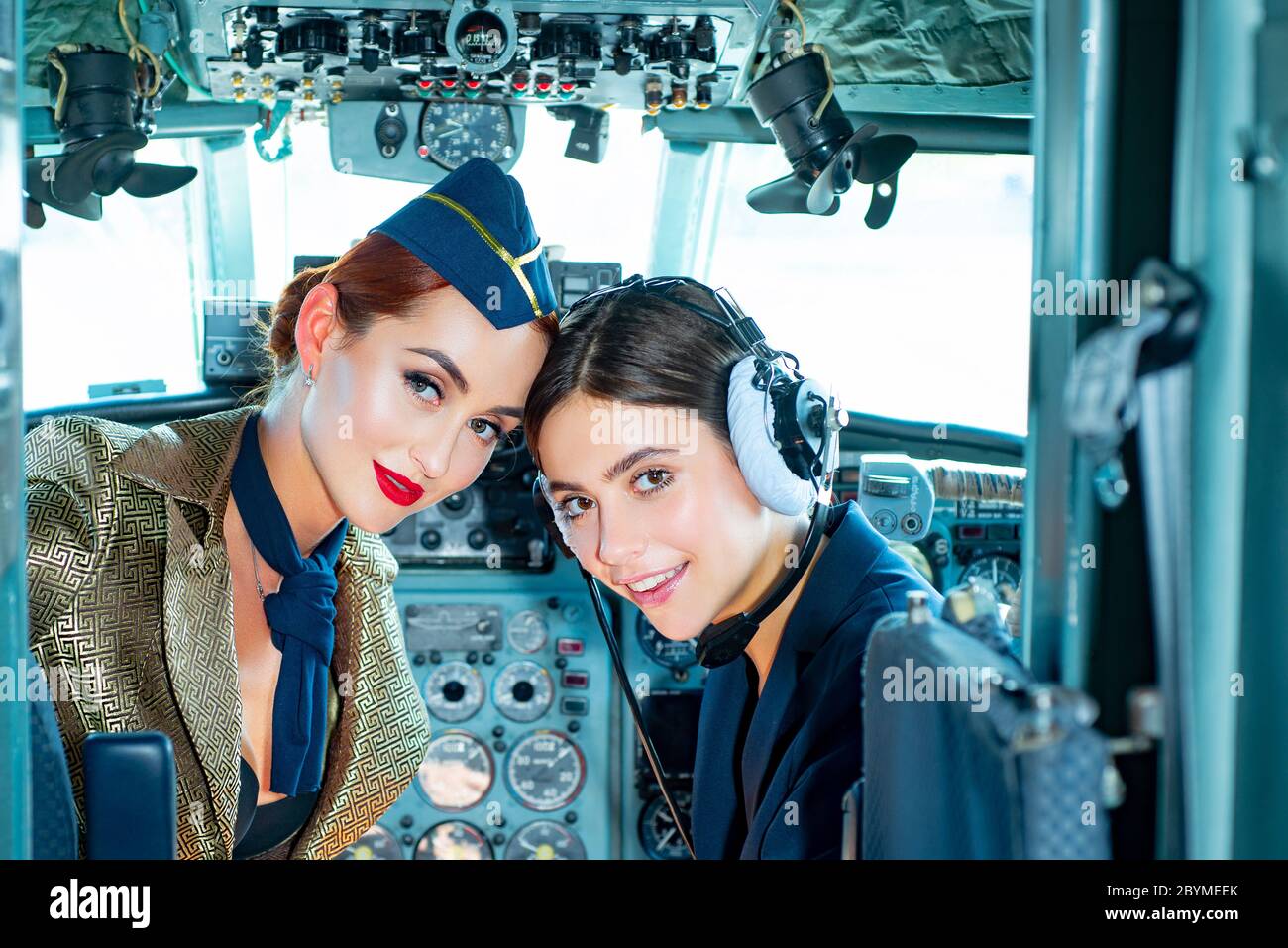 Deux femmes pilotes assis dans la cabine d'avion moderne. Hôtesse souriante dans l'avion. Portrait d'une femme pilote attirante avec préparation de micro-casque Banque D'Images
