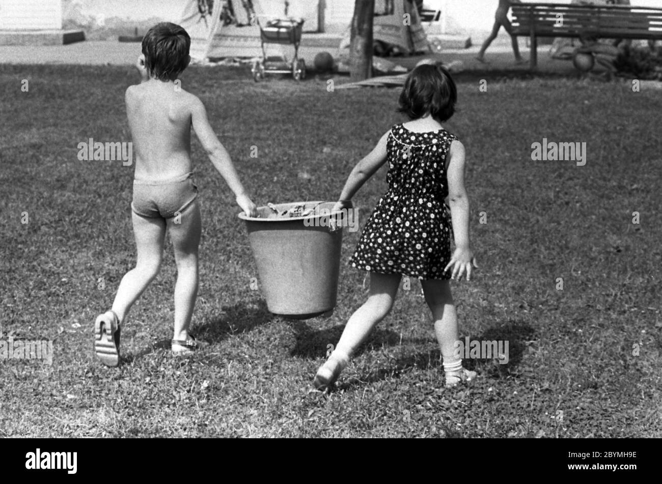 12.03.2019, Berlin, , GDR - garçon et fille portant un seau ensemble dans un jardin d'enfants. 00S840801D002CAROEX.JPG [AUTORISATION DU MODÈLE : NON, AUTORISATION DU PROPRIÉTAIRE : N Banque D'Images
