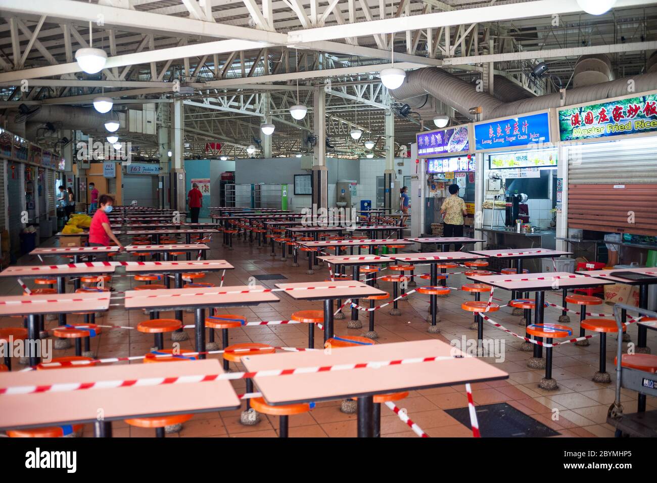 22.04.2020, Singapour, , Singapour - la salle à manger d'un Hawker Centre dans le quartier d'Ang Mo Kio a été enorée avec du ruban rouge et blanc au fu Banque D'Images