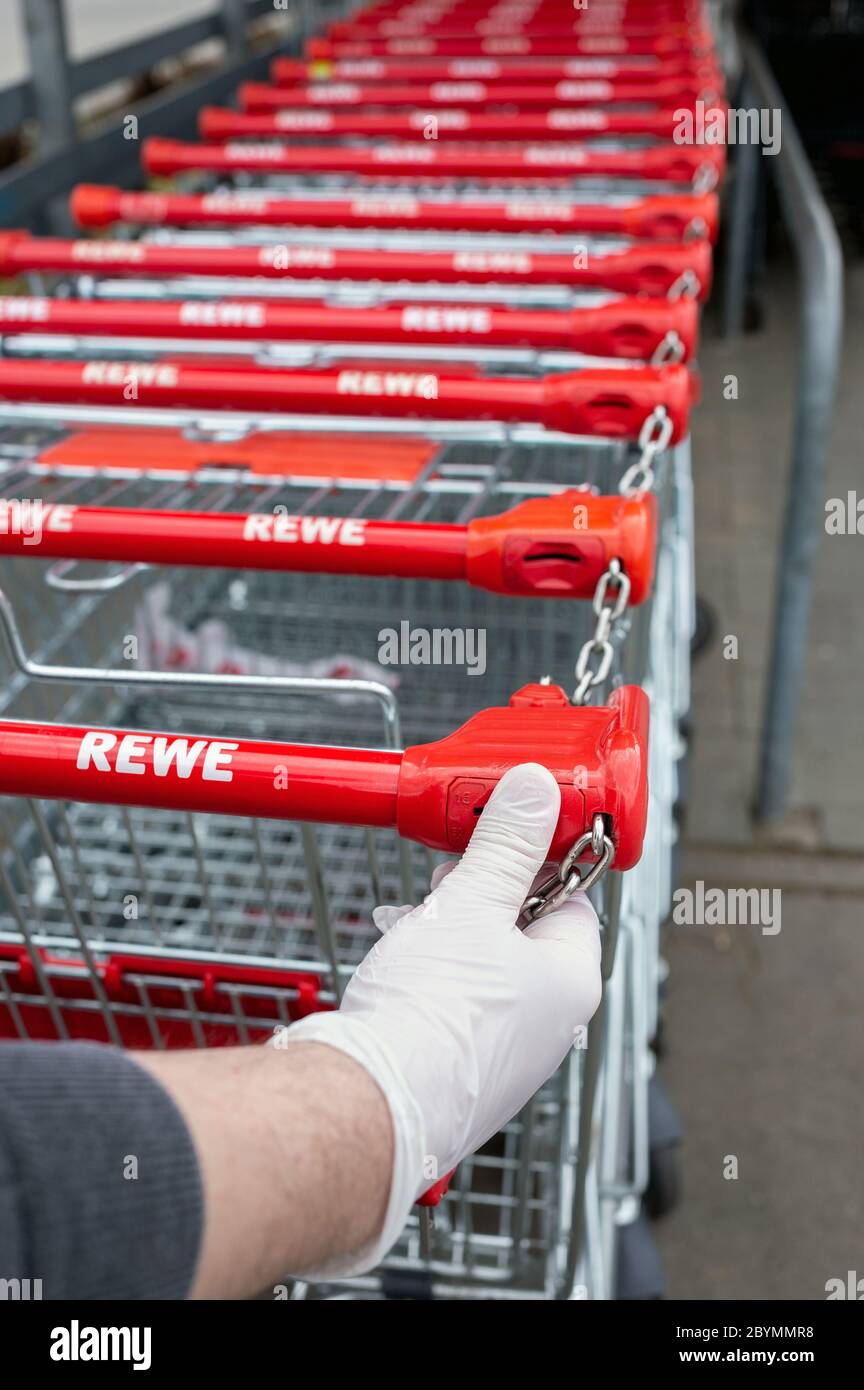 13.04.2020, Berlin, Berlin, Allemagne - main avec des gants jetables sur la poignée d'un chariot à provisions devant un supermarché. MC200413D937CAROEX.JP Banque D'Images