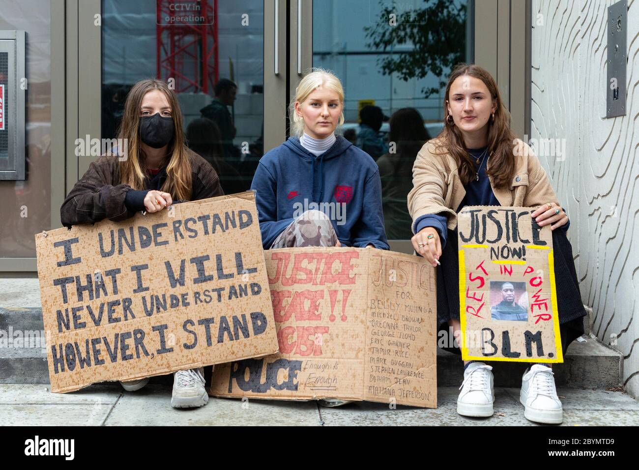 Trois filles blanches s'assoient avec leurs signes de protestation lors d'une manifestation Black Lives Matters, Londres, 7 juin 2020 Banque D'Images
