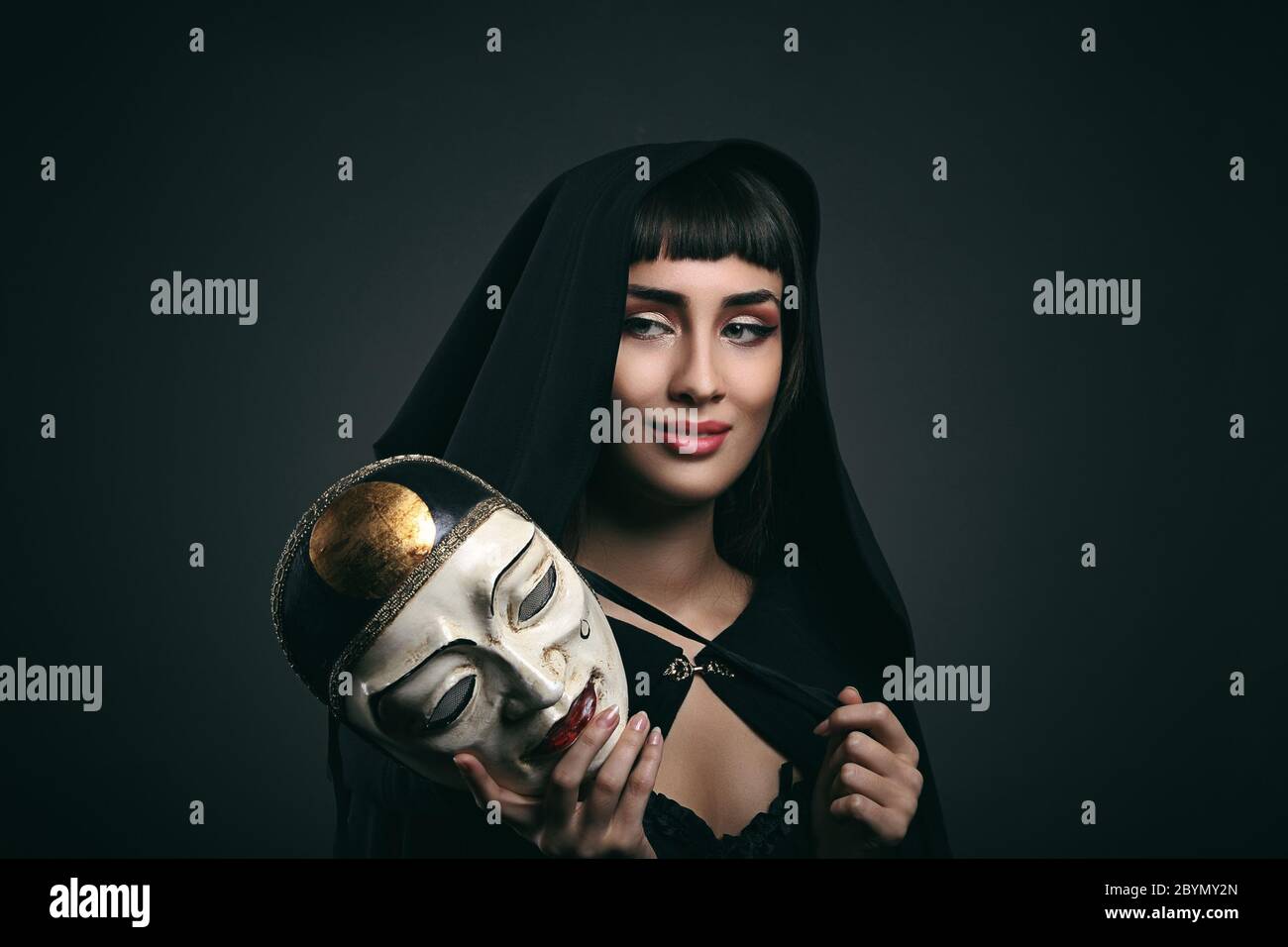 Belle femme avec robe noire et masque. Carnaval vénitien Banque D'Images