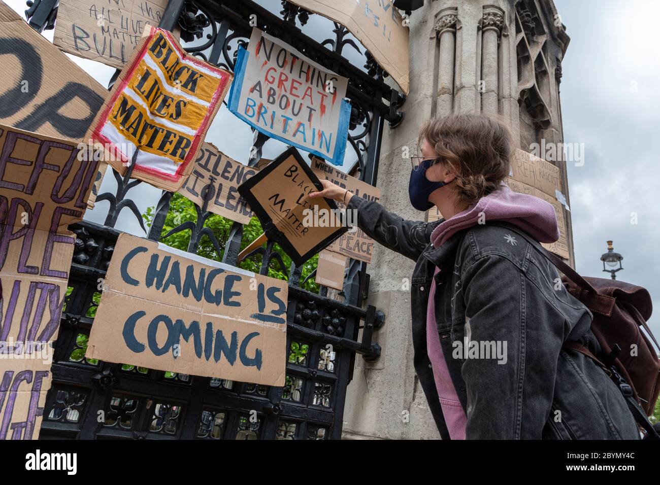 Un manifestant place un panneau sur la clôture du Palais de Westminster après une manifestation Black Lives Matters, Parliament Square, Londres, 7 juin 2020 Banque D'Images