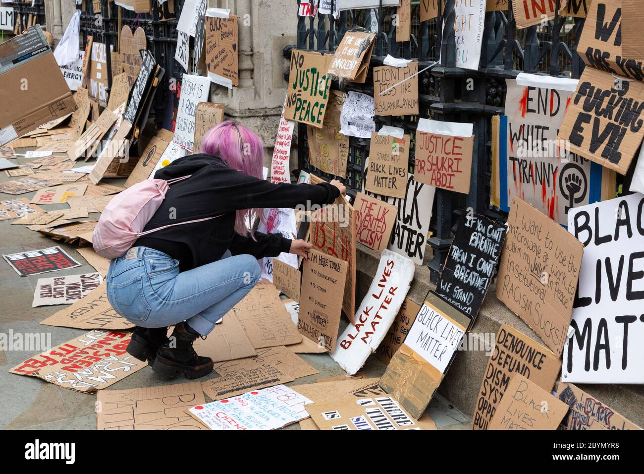 Un manifestant pose un panneau devant le Palais de Westminster après une manifestation Black Lives Matters, Parliament Square, Londres, 7 juin 2020 Banque D'Images