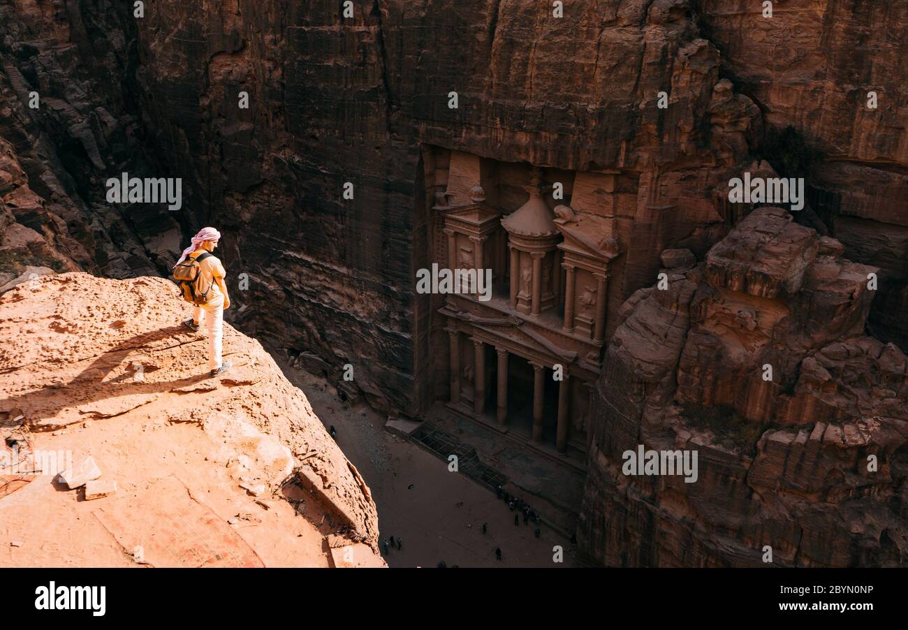 Le randonneur a atteint le sommet de la montagne et a regardé le coucher du soleil. Belle vue sur le paysage Al Khazneh - le trésor, ancienne ville de Pétra, Jordanie Banque D'Images