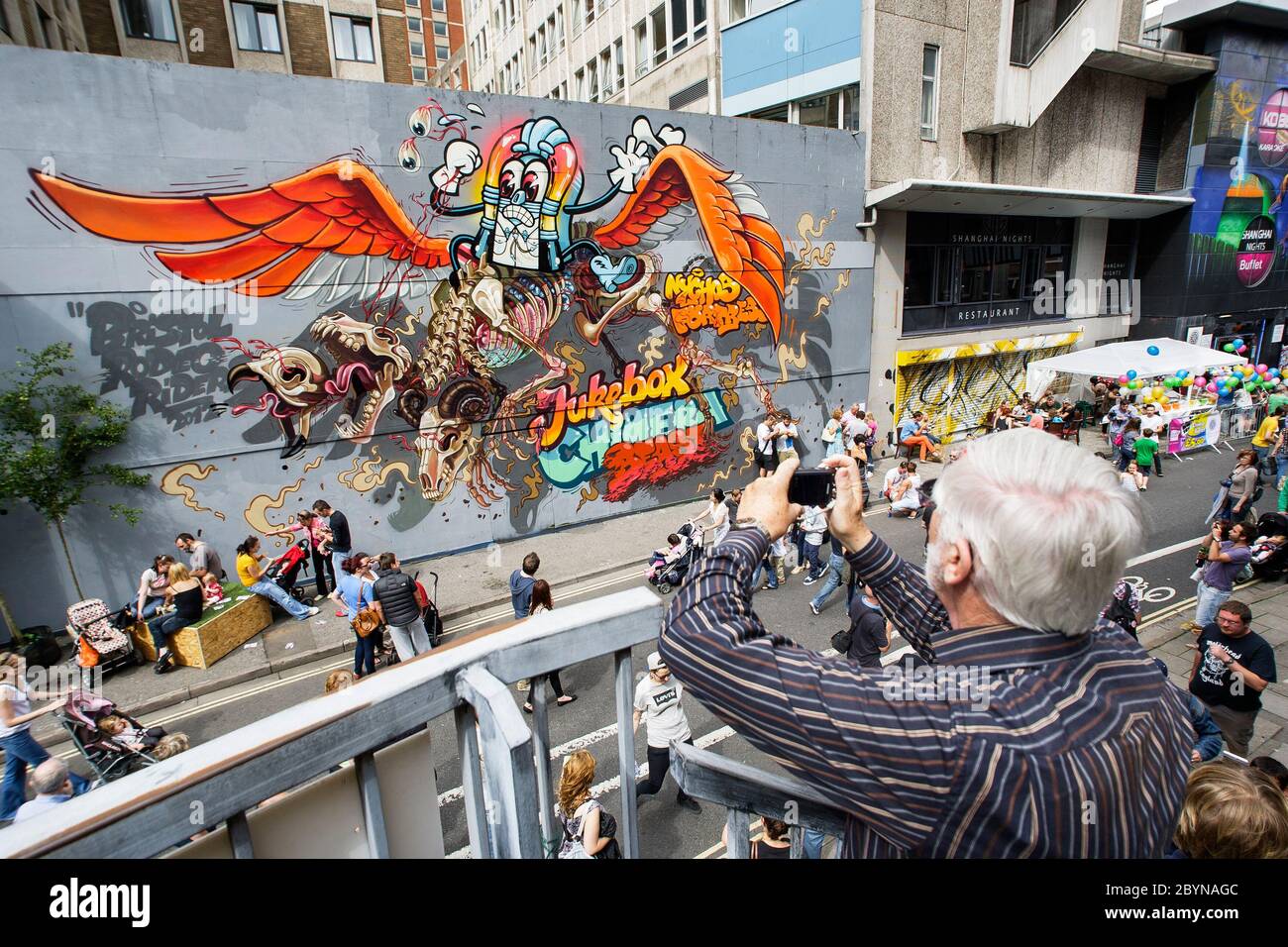 Un homme prend une photo d'œuvres d'art urbain peintes sur des bâtiments de la rue Nelson dans le cadre du projet de travail Voir No Evil Art. Août 2012 Banque D'Images