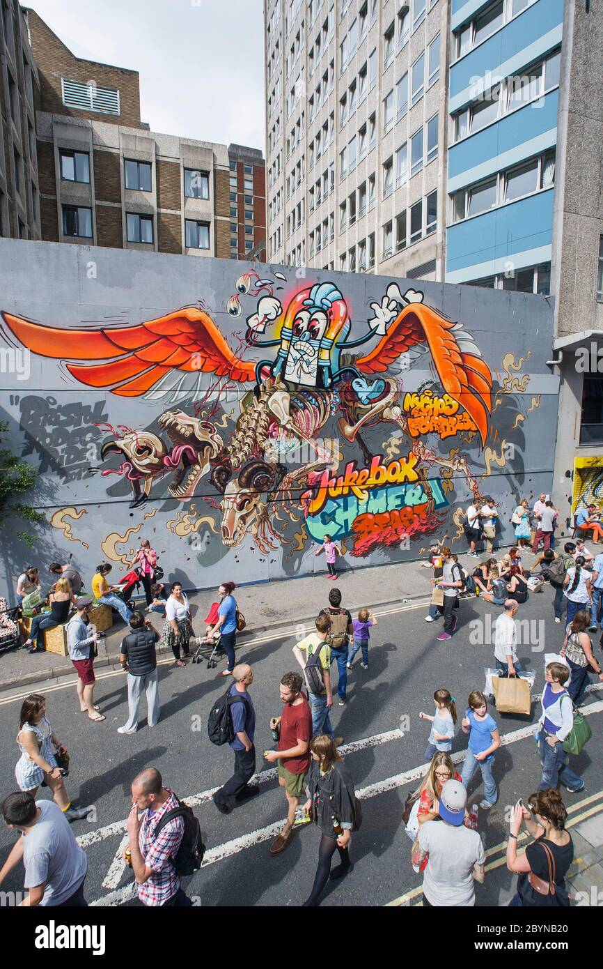 Les visiteurs du festival de travail d'art See No Evil sont photographiés en marchant devant des œuvres d'art urbaines peintes à l'extérieur des bâtiments de Nelson Street. Août 2012 Banque D'Images