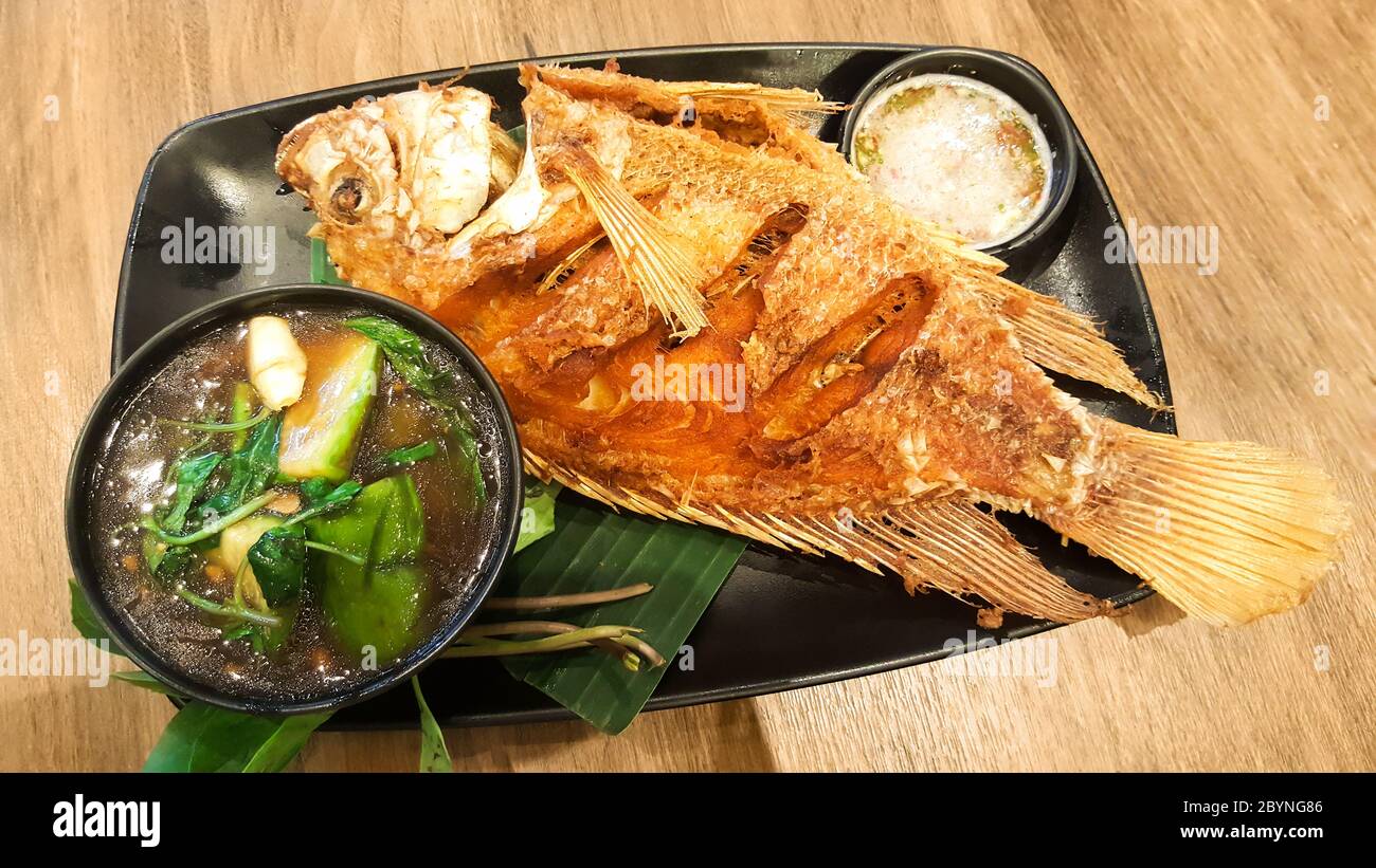 poisson frit sur un plat noir Banque D'Images