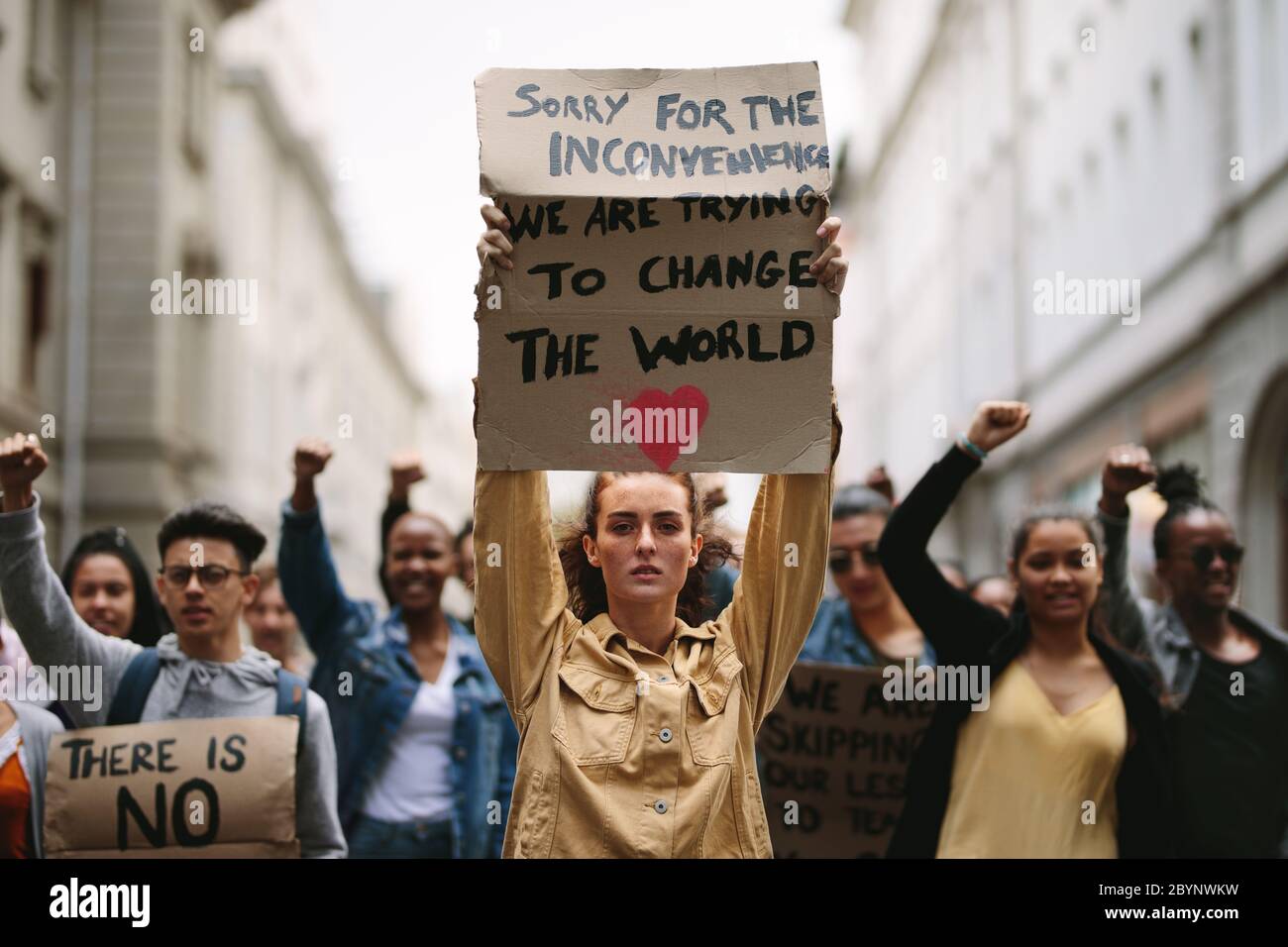 Jeune étudiant tenant une affiche et protestant. Groupe de manifestants protestant contre le changement climatique. Banque D'Images