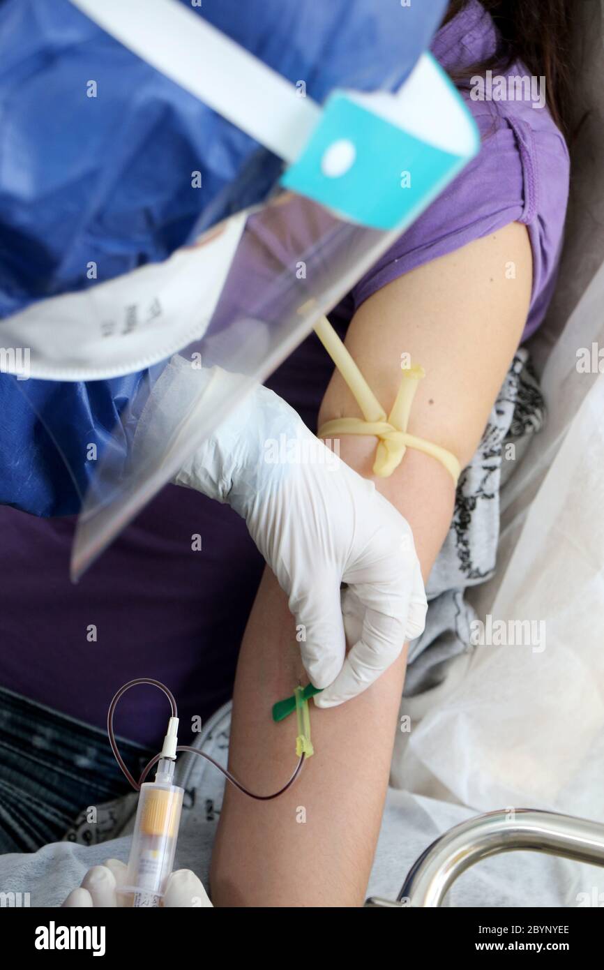 L'infirmière prélève un échantillon de sang d'un patient pour un test sanguin en raison d'un cas possible de coronavirus covid-19 Banque D'Images