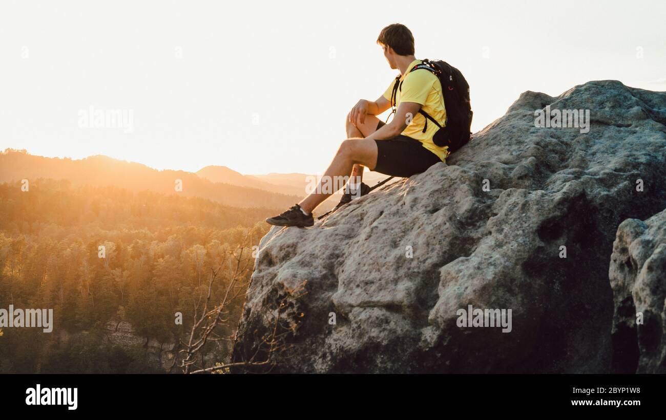 Le voyageur se détende sur le bord de la montagne. Nature et aventure. Au coucher du soleil. Scène spectaculaire et magnifique. Un moment magnifique Banque D'Images