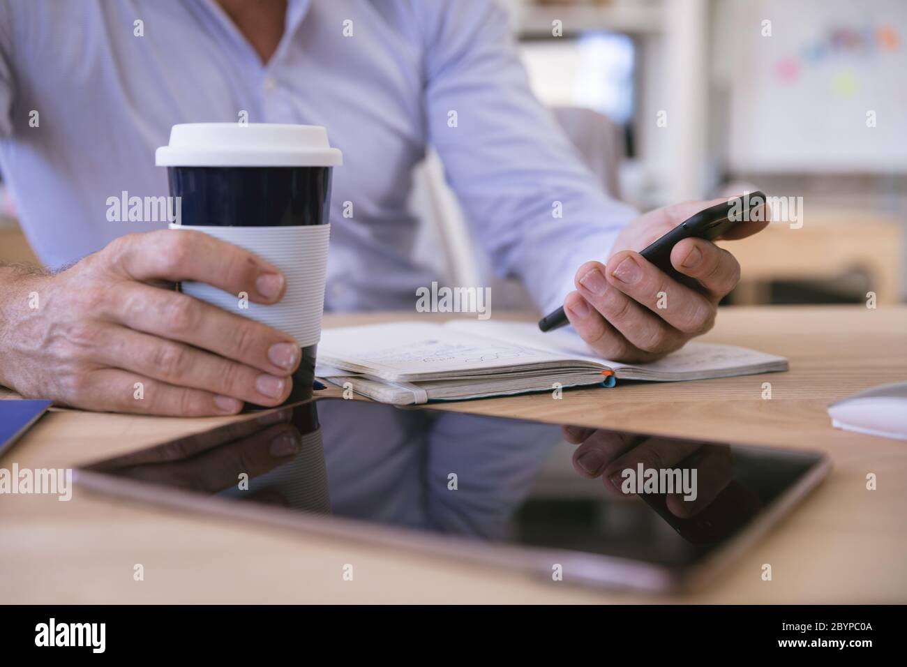 Homme caucasien tenant le téléphone et le café Banque D'Images