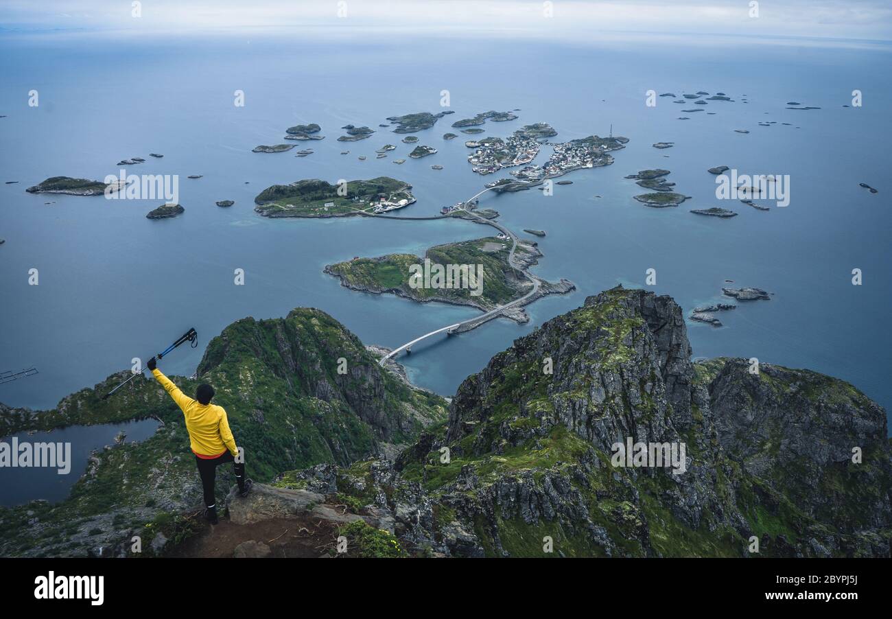 Un randonneur haut avec vue panoramique sur la côte et les îlots de Henningsvaer. Vue sur la vallée depuis un point de vue vallonné Banque D'Images