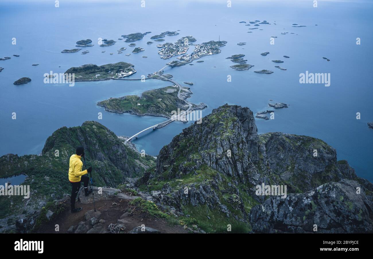 Un randonneur haut avec vue panoramique sur la côte et les îlots de Henningsvaer. Vue sur la vallée depuis un point de vue vallonné Banque D'Images