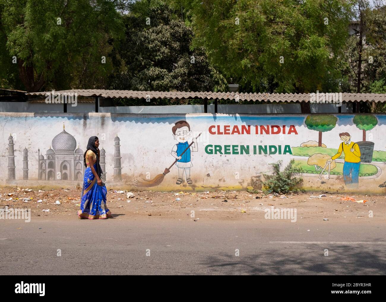 Femme locale marchant devant un mur avec un slogan favorisant une Inde propre, Aurangabad, Maharashtra, Inde. Banque D'Images