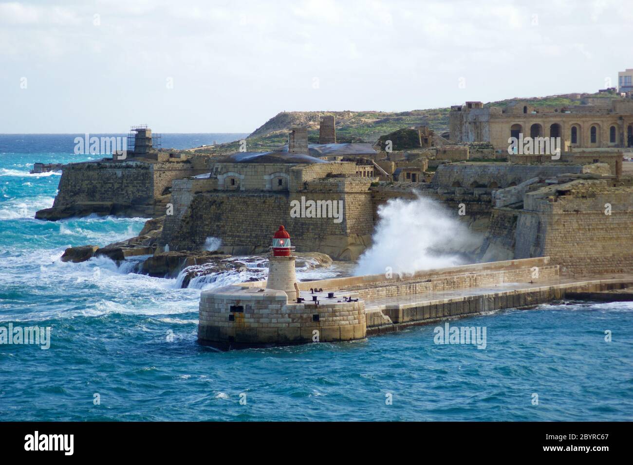 VALLETTA, MALTE - 31 décembre 2019 : vue du fort St Elmo sur le Grand Port de Ricasoli, brise-lames et phare rouge pendant les vagues fortes Banque D'Images