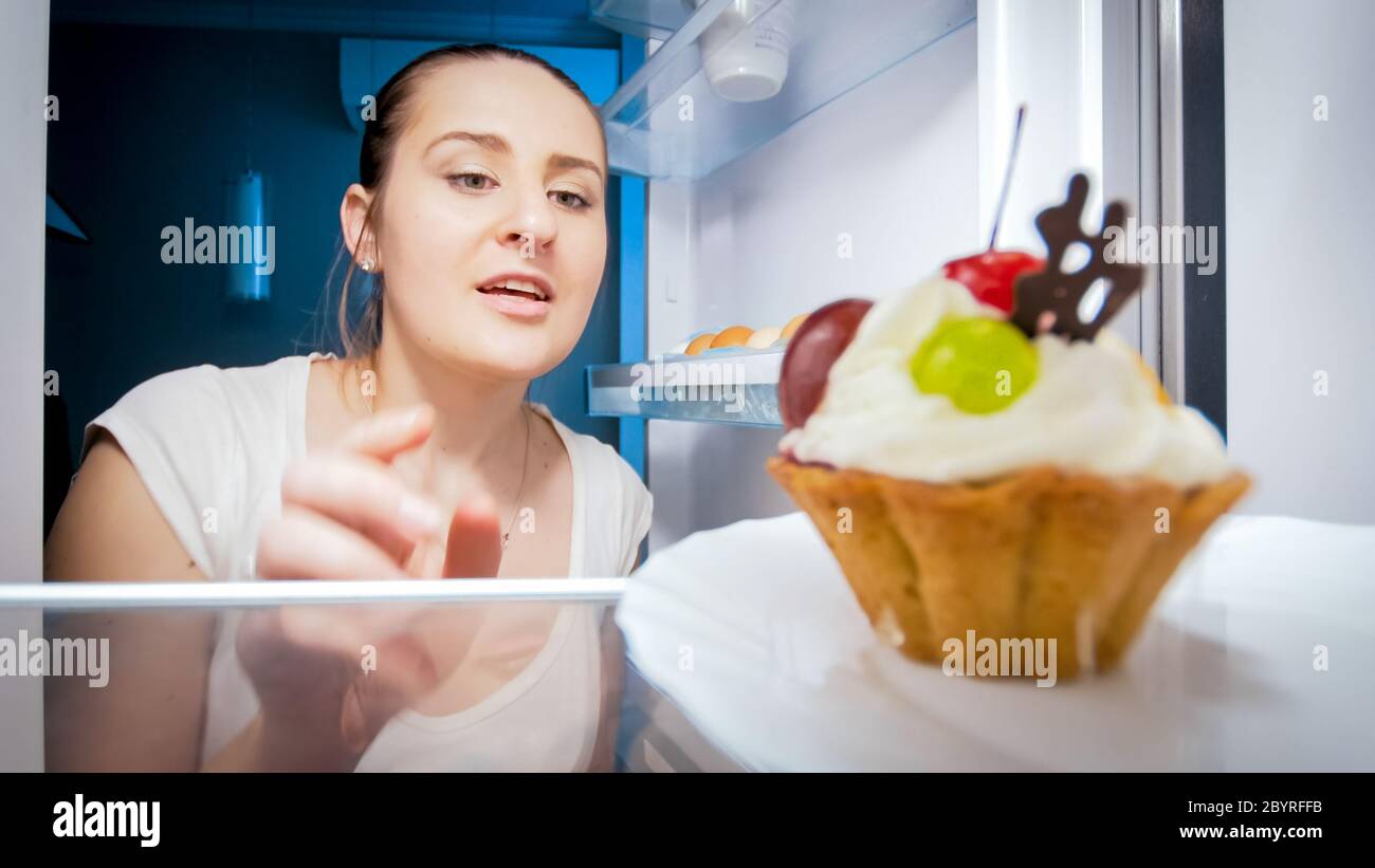 Femme affamée à la recherche de quelque chose à manger dans la cuisine la nuit. Concept de régime alimentaire et de nutrition saine Banque D'Images