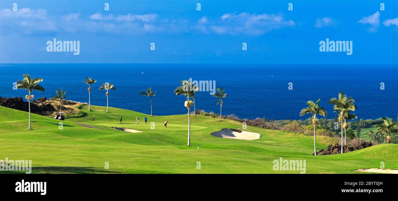 Panorama des golfeurs sur le green du parcours de montagne de Kona Country Club (propriété libérée) à Kailua Kona, Hawaï avec l'océan Pacifique à distance. Banque D'Images
