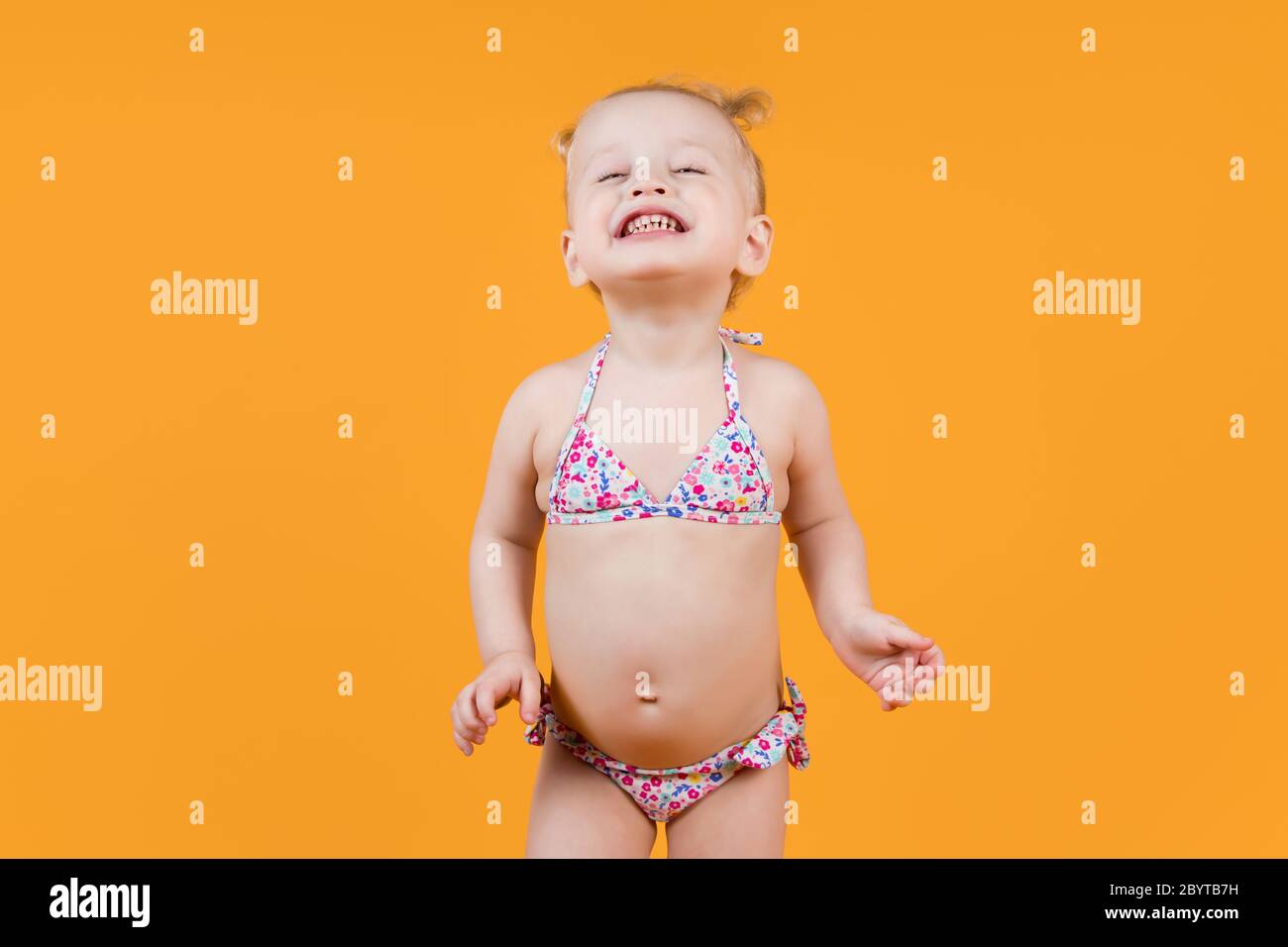 fille dans un maillot de bain sourit dans toutes les dents, drôle de bourdonner des yeux Banque D'Images