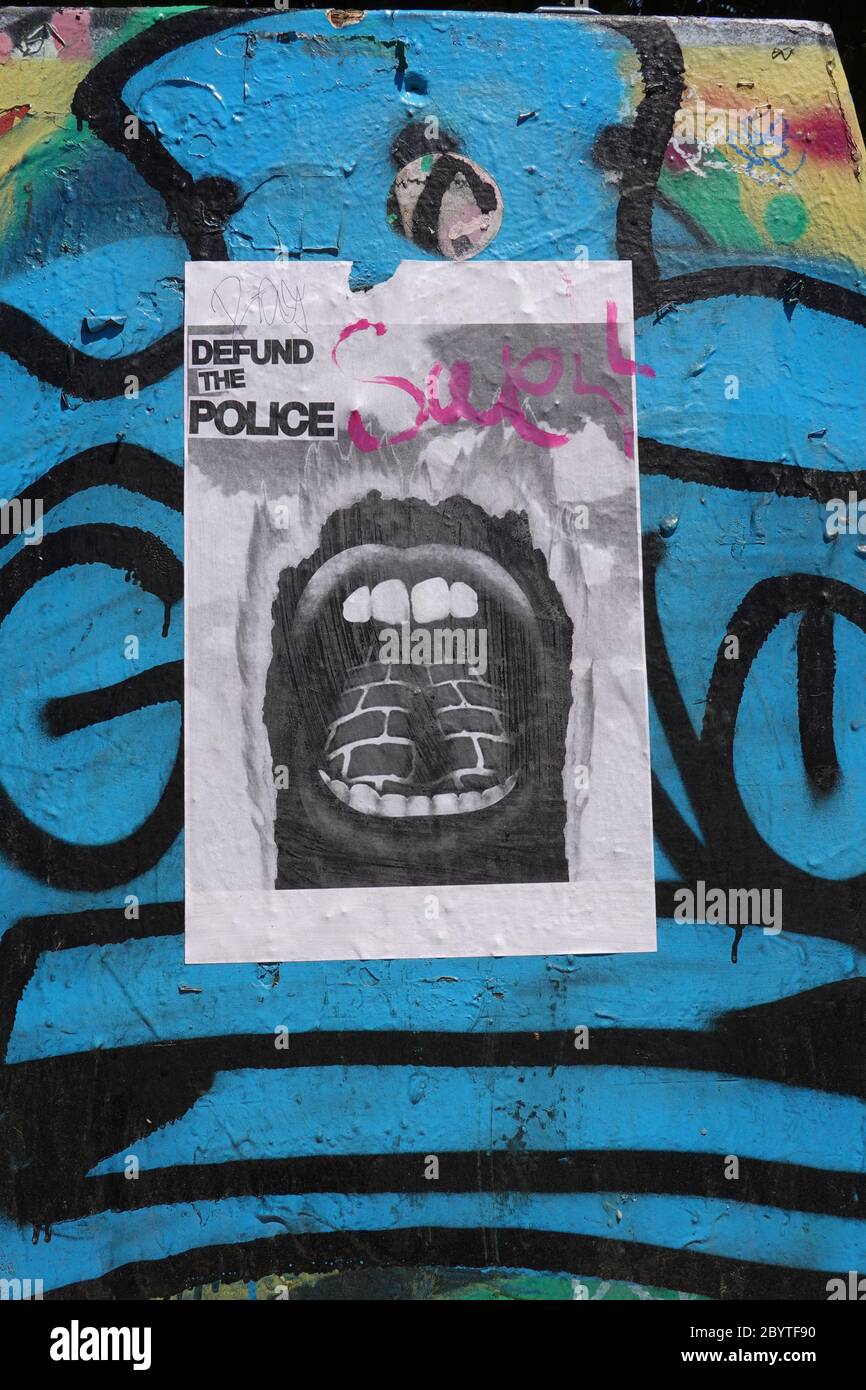 Un dé-fonds du flier de police est suspendu sur un mur recouvert de graffiti. Banque D'Images