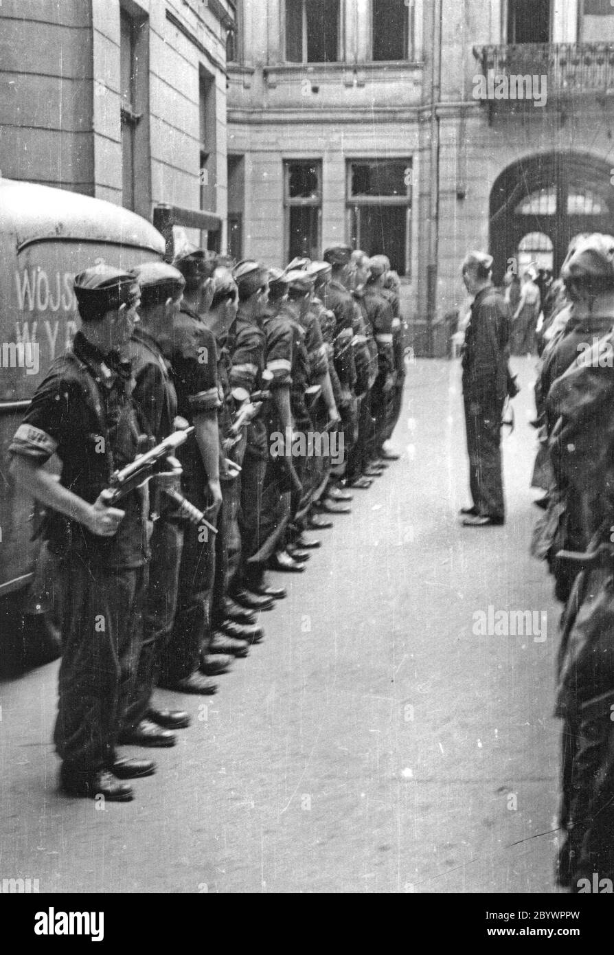 Soulèvement de Varsovie : débriefing du II peloton Oddziału Odłonowego WZW „Chwaty” sous le commandement de Stefan Berent „Steb dans la cour d'une maison de ville de la rue Bowdena. A l'arrière, une voiture avec “WZW” sur son côté. CA. Août 1944 Banque D'Images