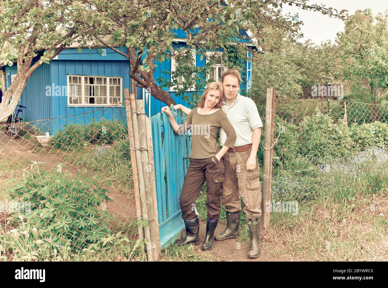 Jeune paire heureuse à une porte de la maison de campagne. Banque D'Images