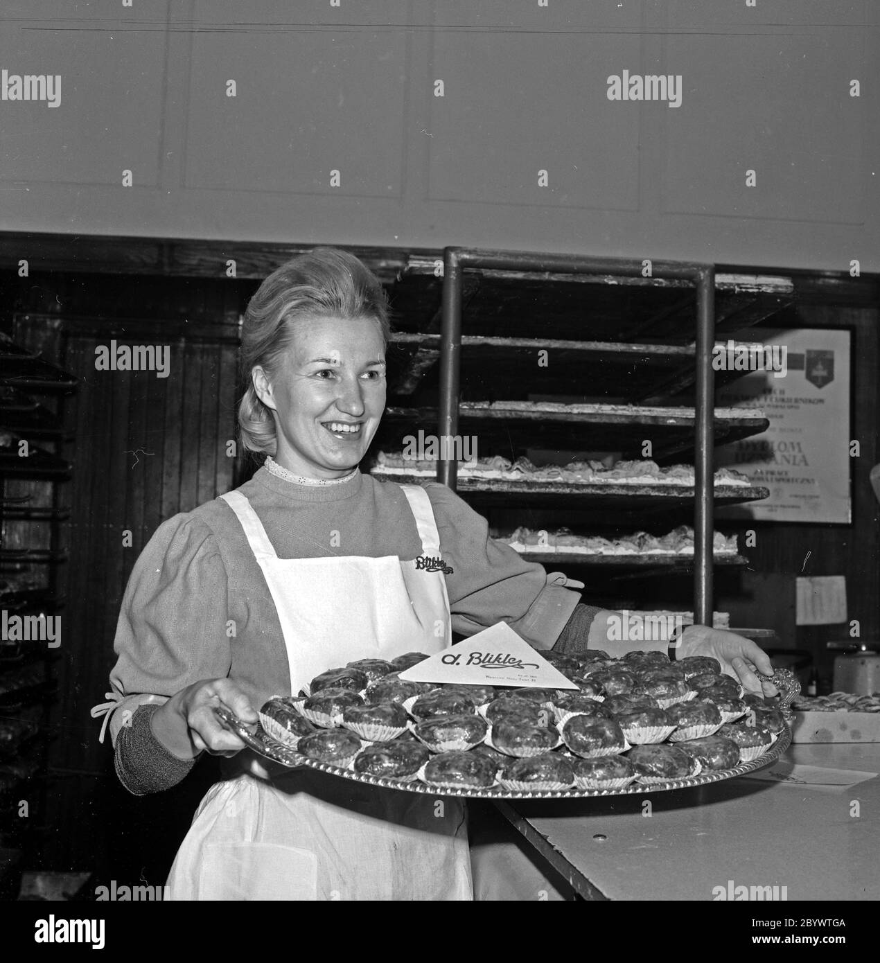 Une femme portant un plateau de pączki (beignets remplis) à la pâtisserie de Bikle à Varsovie ca. 1969-1978 Banque D'Images