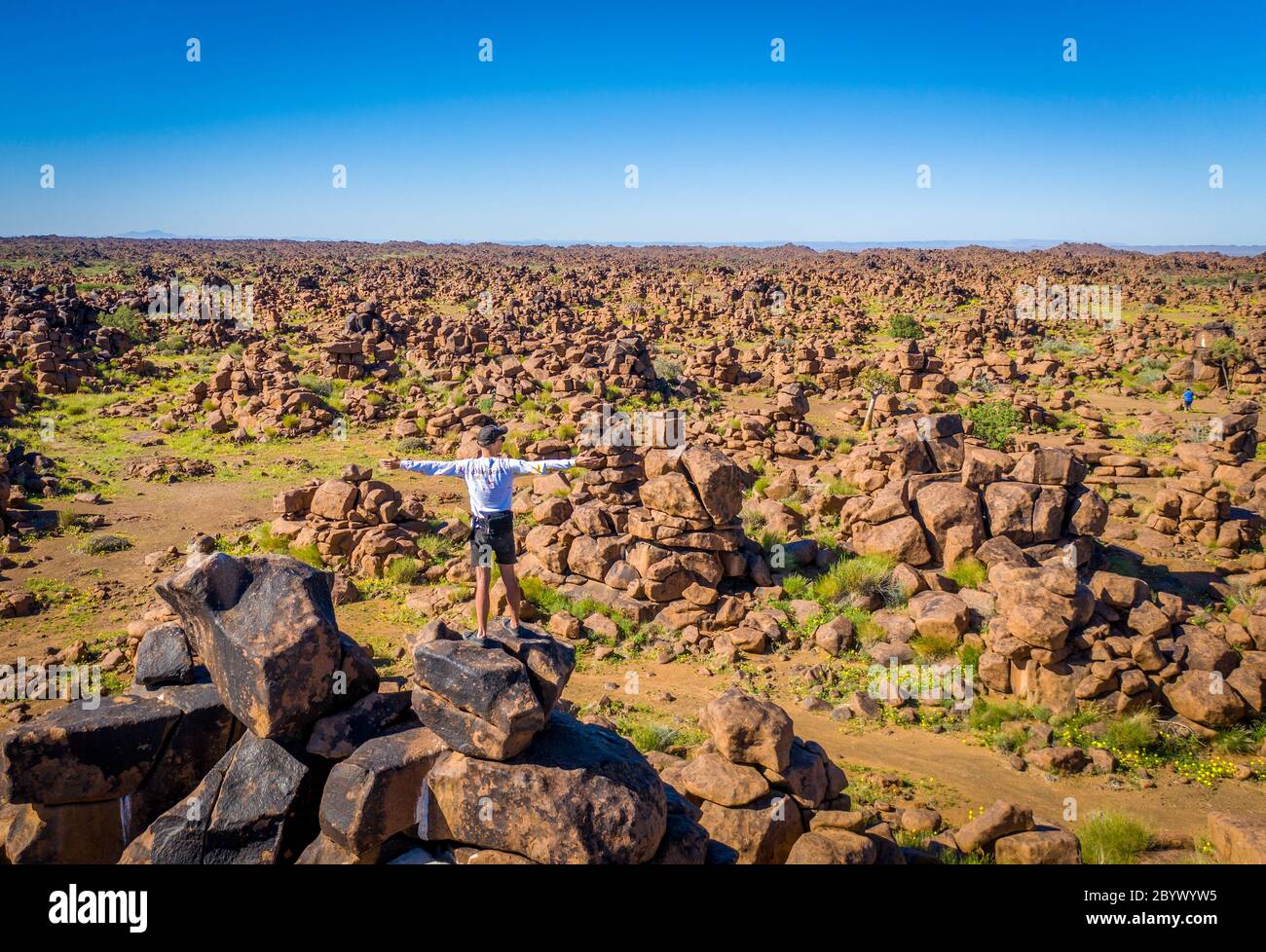 Une personne debout au sommet des rochers dans le terrain de jeu des géants , Keetmanshoop, Namibie Banque D'Images