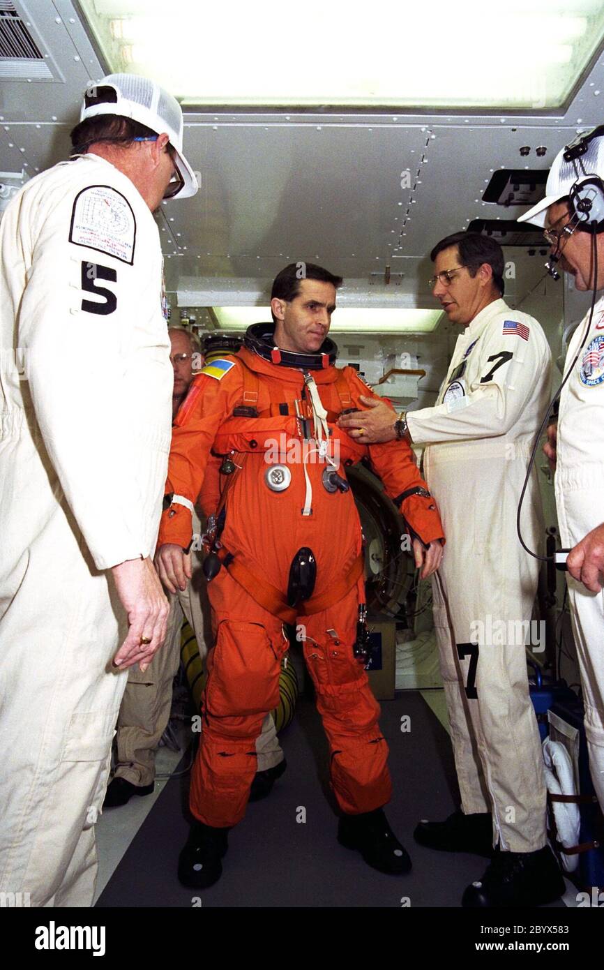 Le spécialiste de la charge utile STS-87 Leonid Kadenyuk de l'Agence spatiale nationale d'Ukraine (AINS) est assisté par des techniciens de la NASA qui lancent des combinaisons orange et effectuent des essais de mise à l'épreuve du compte à rebours au terminal 39B. Le lancement de l'équipage de la mission STS-87 est prévu le 19 novembre à bord de la navette spatiale Columbia. Le TCDT se tient au KSC avant chaque vol de la navette spatiale, offrant à l'équipage de chaque mission des occasions de participer à des activités simulées de compte à rebours. Le TCDT se termine par un faux décompte de lancement qui aboutit à une simulation de coupure du moteur principal. TH Banque D'Images