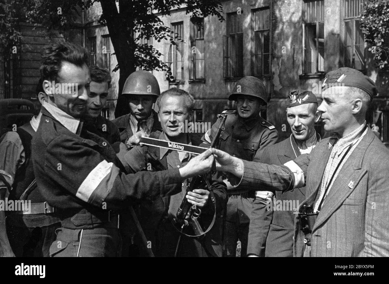 Soulèvement de Varsovie: Cyprien Capitan Odorkiewicz 'Krybar' comander du 'Krybar' Regiment (à droite) lors de l'inspection d'un transporteur militaire allemand capturé ('szary Wilk') dans les jardins d'Okólnik. Wacław Jastrzębowski 'Saspira' présente les insignes de la 5e SS Panzergrenadier Division 'Wiking'. Au milieu, un insurgé avec le canon de sous-machine MP40 allemand ca. 1944 Banque D'Images