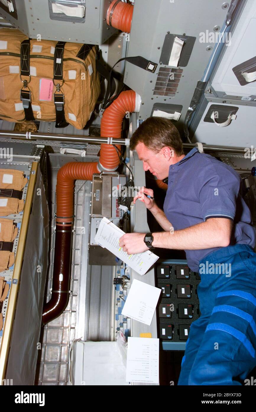 (13 janv. 1997) --- l'astronaute Brent W. Jett, Jr., pilote, passe en tête d'une liste de contrôle des expériences et des fournitures dans l'environnement à manchon d'étredu module Spacehab Double (DM) apposé dans la baie de cargaison de la navette spatiale Atlantis. Cette image a été enregistrée avec une caméra électronique fixe (ESC) et a été ensuite reliée aux contrôleurs de vol de Houston, Texas. Banque D'Images