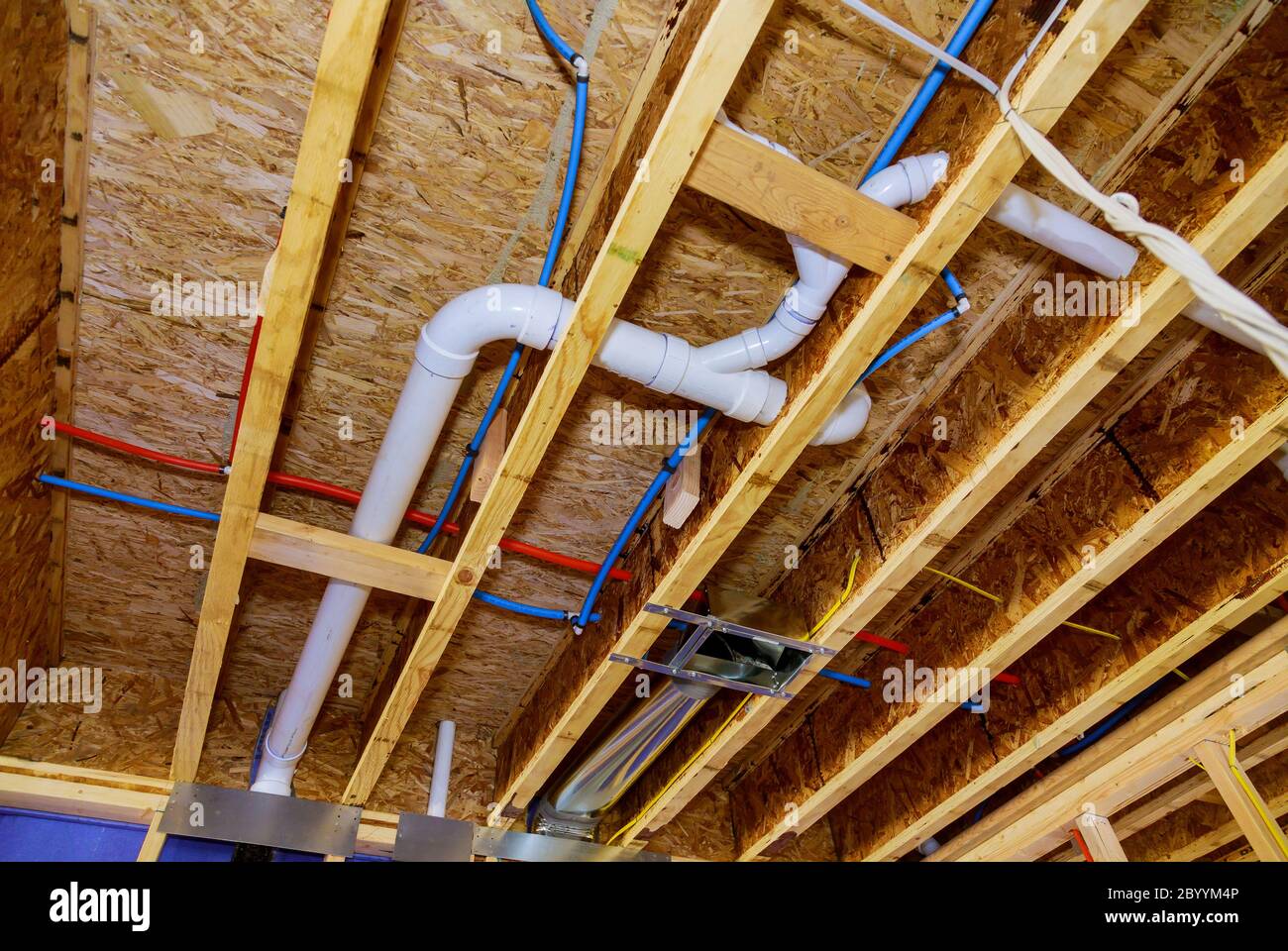 Construction de maison avec rouge chaud et bleu froid pex tuyauterie dans  les tuyaux et poutres apparentes Photo Stock - Alamy