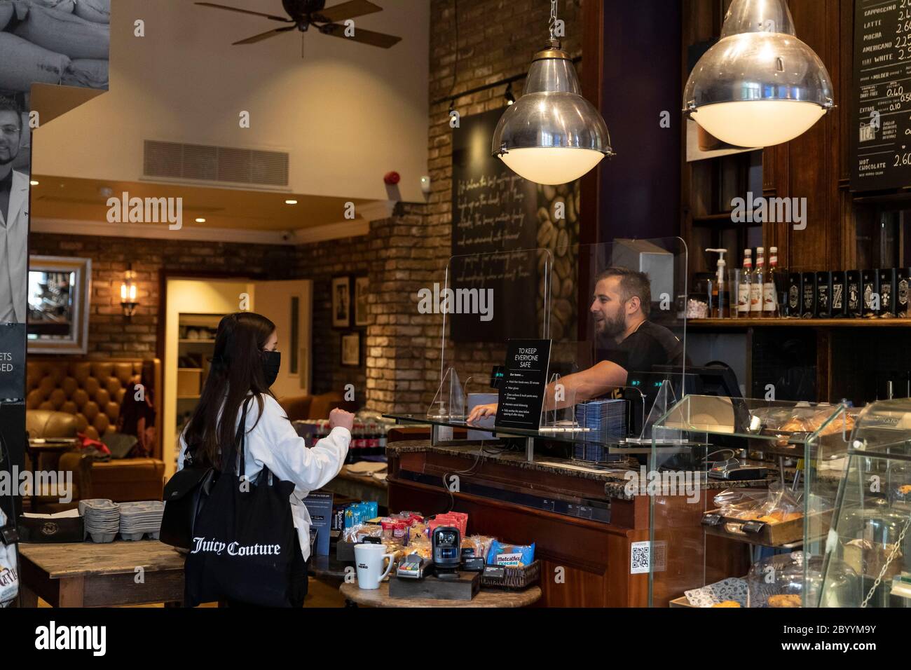 Londres, Royaume-Uni. 10 juin 2020. Un membre du personnel (R) s'entretient avec un client d'un Caffe Nero qui a rouvert ses portes pour des plats à emporter à Maida Vale à Londres, en Grande-Bretagne, le 10 juin 2020. Certains cafés britanniques ont rouvert pour des plats à emporter ou des livraisons, avec des règles de distanciation sociale suivies. Credit: Han Yan/Xinhua/Alay Live News Banque D'Images