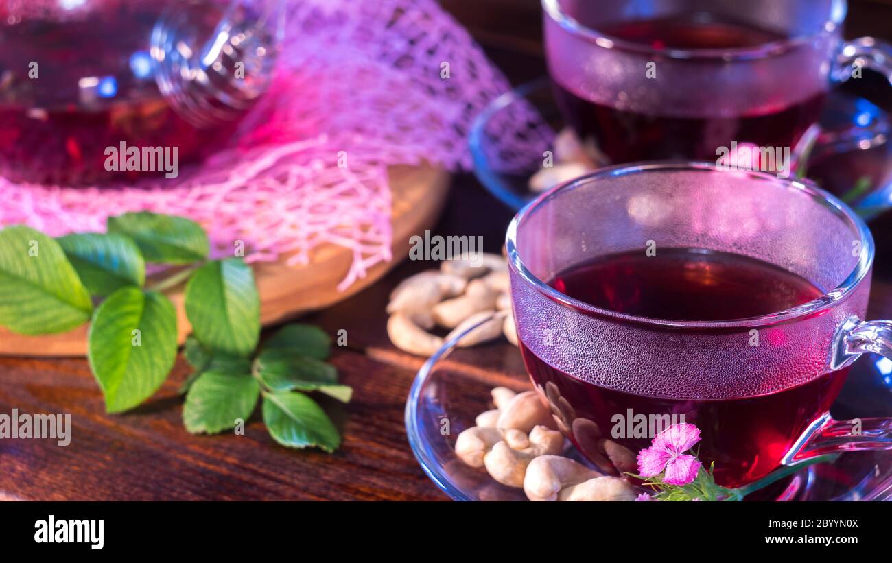 Thé anglais. Thé rouge hibiscus chaud dans une tasse en verre. Temps de thé : tasse de thé, carcade, karting, rooibos. Oriental, confortable, cérémonie, tradition, japonais, verdoyant, Banque D'Images
