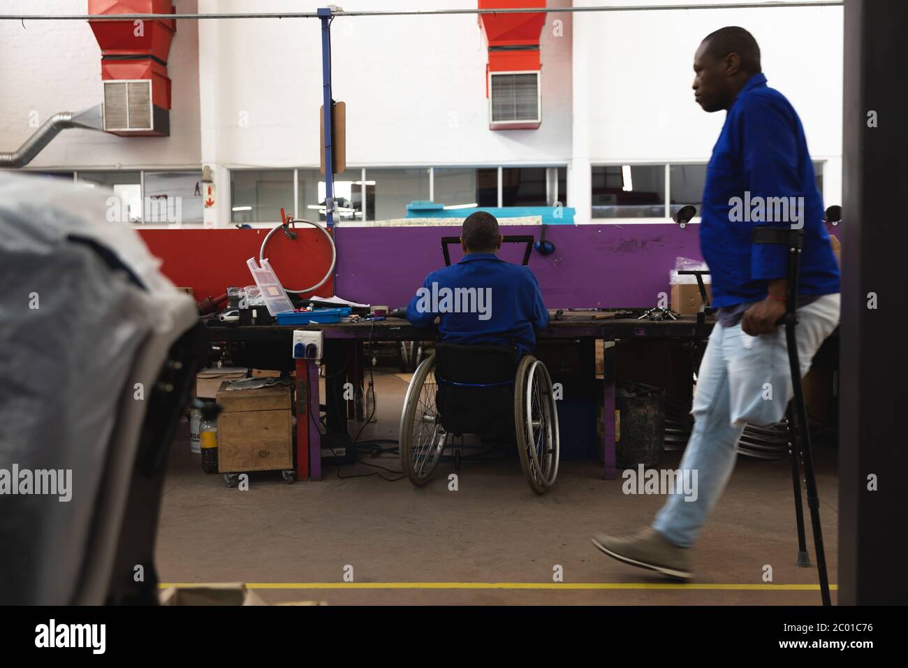 Travailleurs handicapés créant des fauteuils roulants dans les entrepôts Banque D'Images