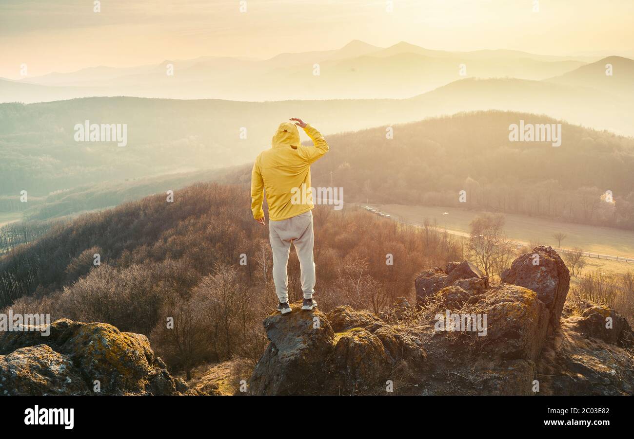 Homme au sommet d'une montagne en pleine ascension. Silhouette d'un homme sur la montagne au coucher du soleil Banque D'Images