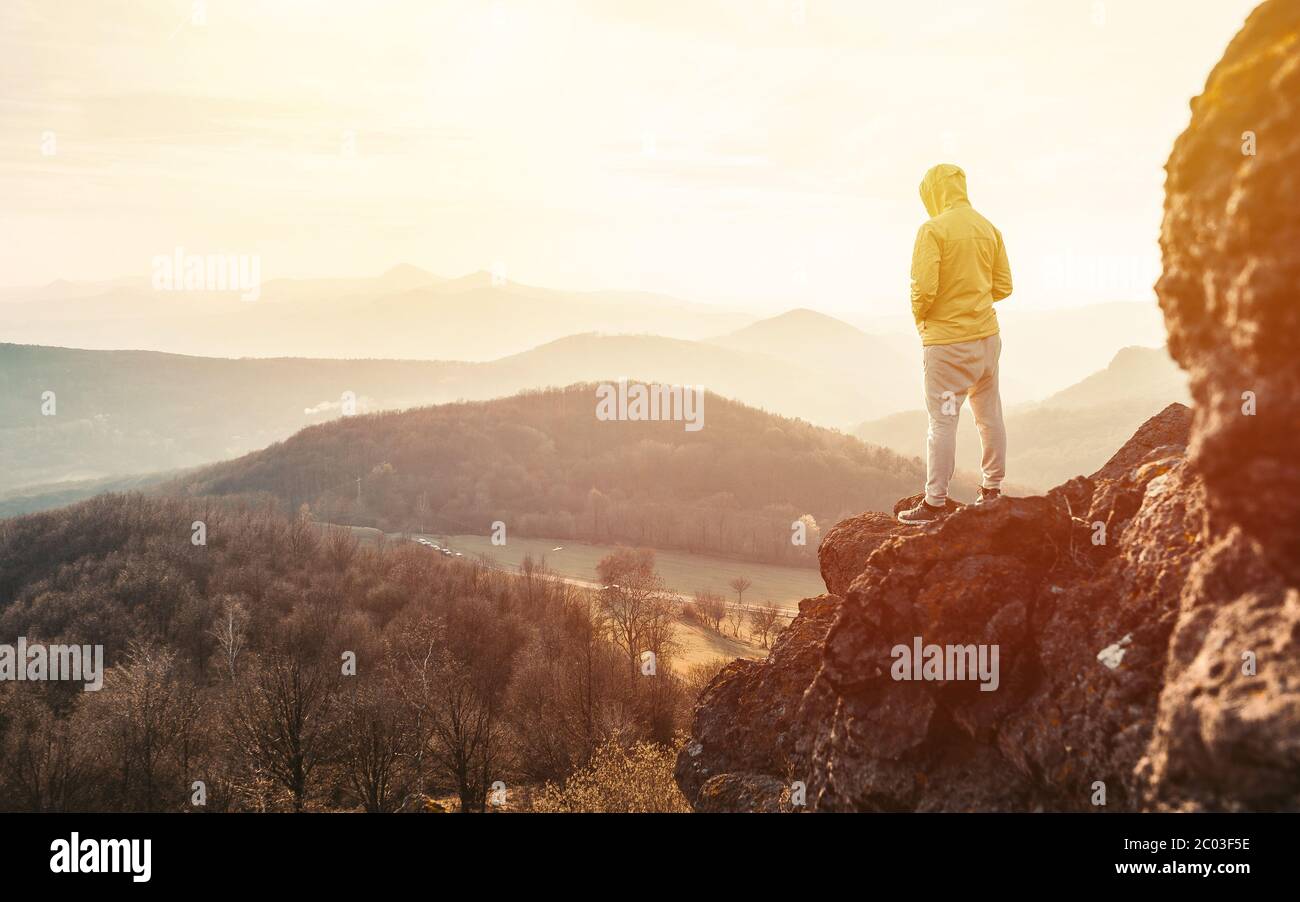 Homme au sommet d'une montagne en pleine ascension. Silhouette d'un homme sur la montagne au coucher du soleil Banque D'Images