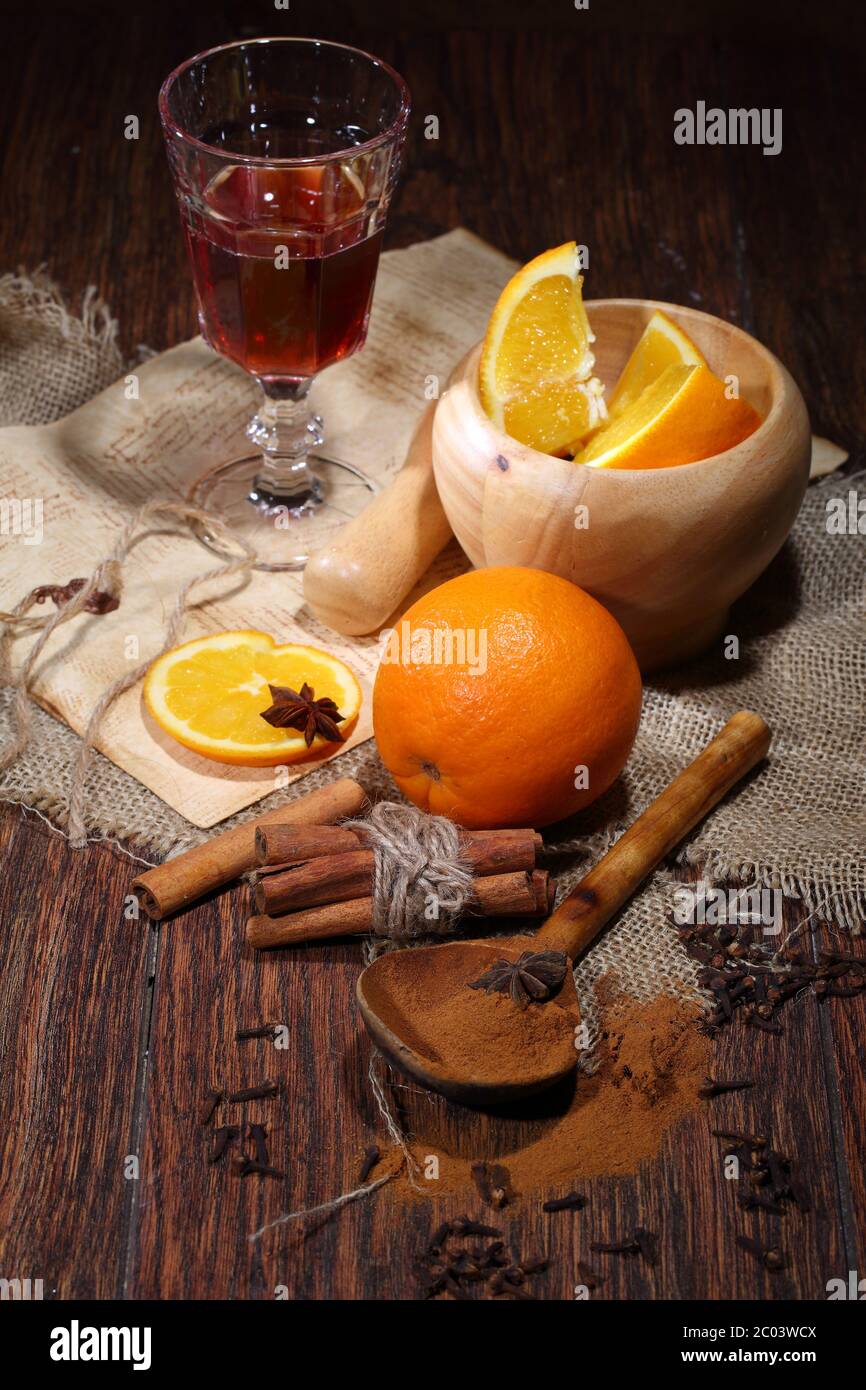 Préparation de vin chaud avec ajout d'une orange, miel, cannelle, une carnation et une anis Banque D'Images