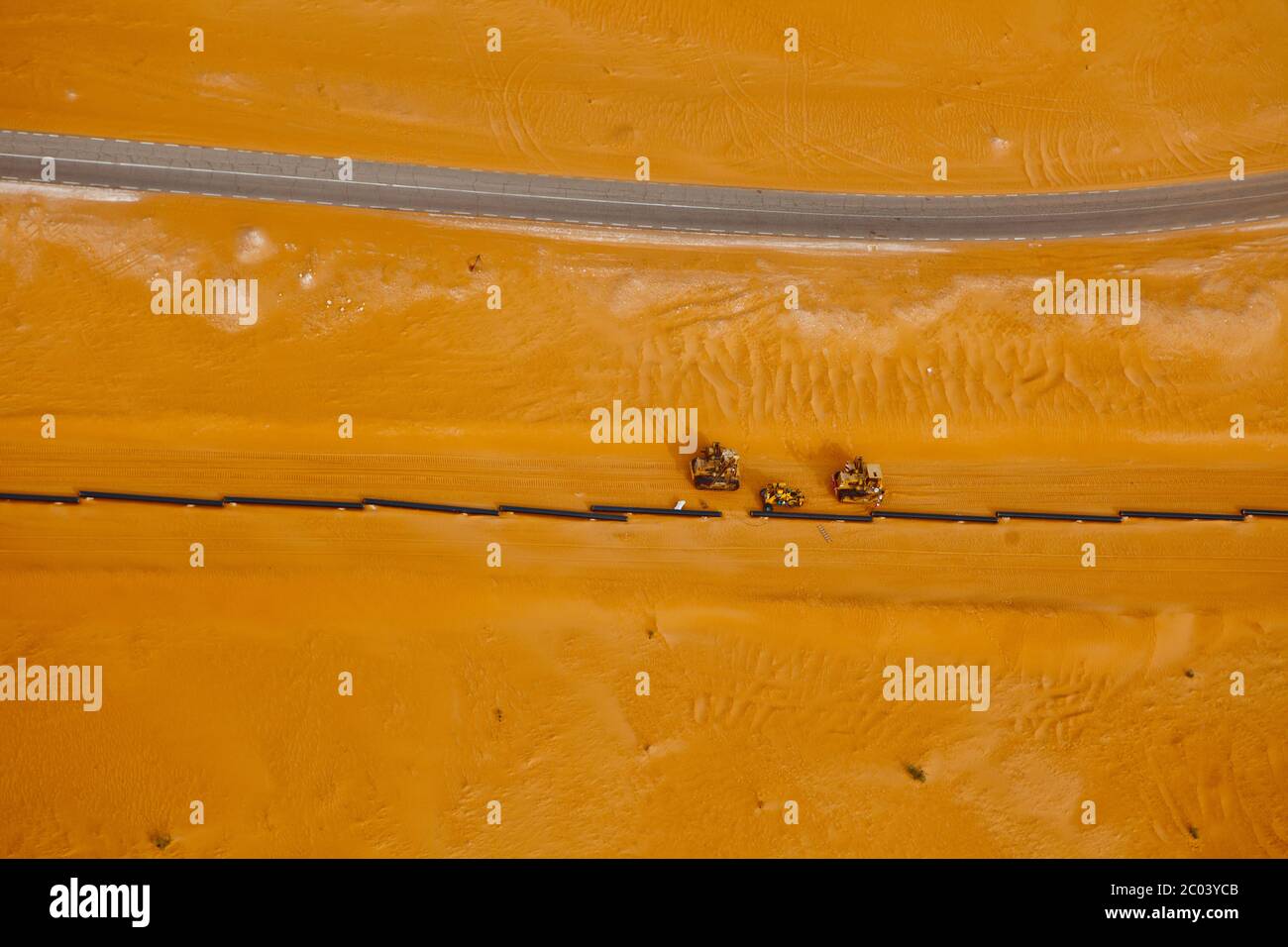 Bull bulldozers aplatissement du sable pour la construction d'une route de gypse afin de faciliter le soudage d'un pipeline d'exportation de pétrole dans le désert du Sahara. Banque D'Images