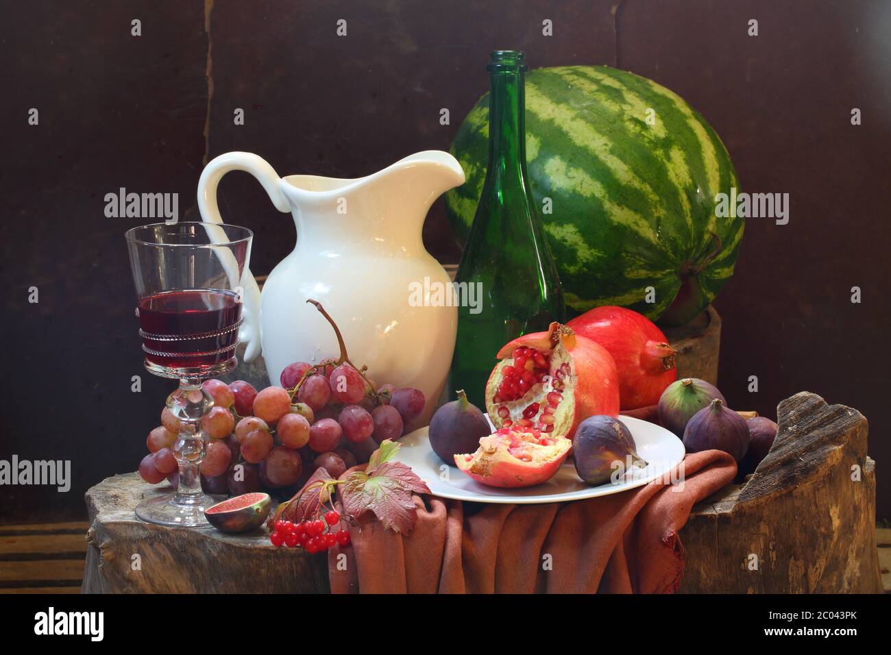 Vin, raisin, grenade, figue, melon d'eau et verseuse blanche Banque D'Images