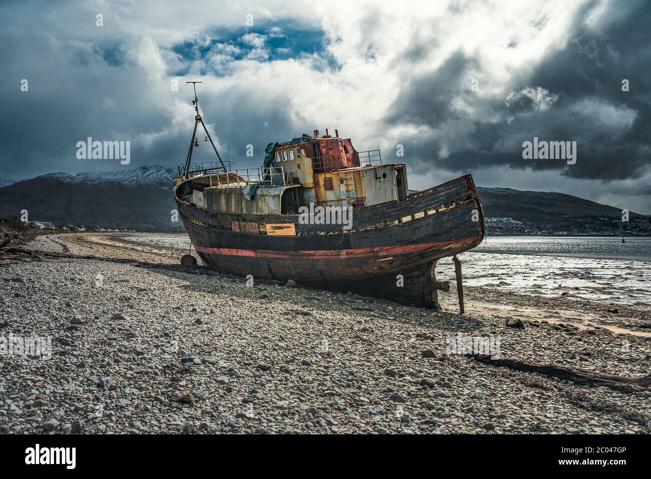 Épave de bateau sur la plage à marée basse. Le vieux bateau de Corpach, Ben Navis sur le Loch Eil près de fort William en Écosse. Banque D'Images