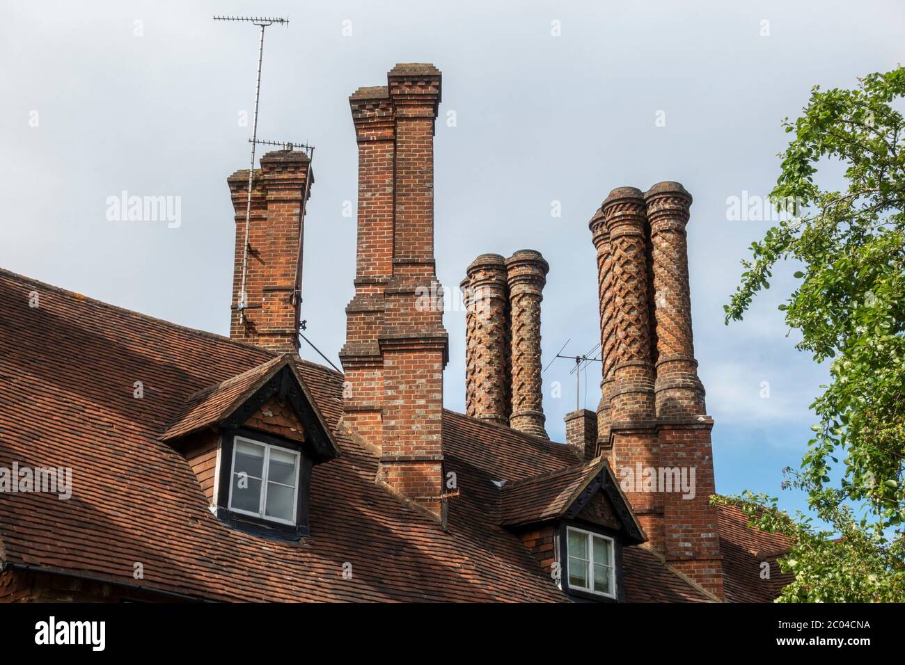 Cheminées en briques aux ornements incroyables (y compris l'ancien bureau de poste) à Albury, Surrey, Angleterre, Royaume-Uni. Banque D'Images