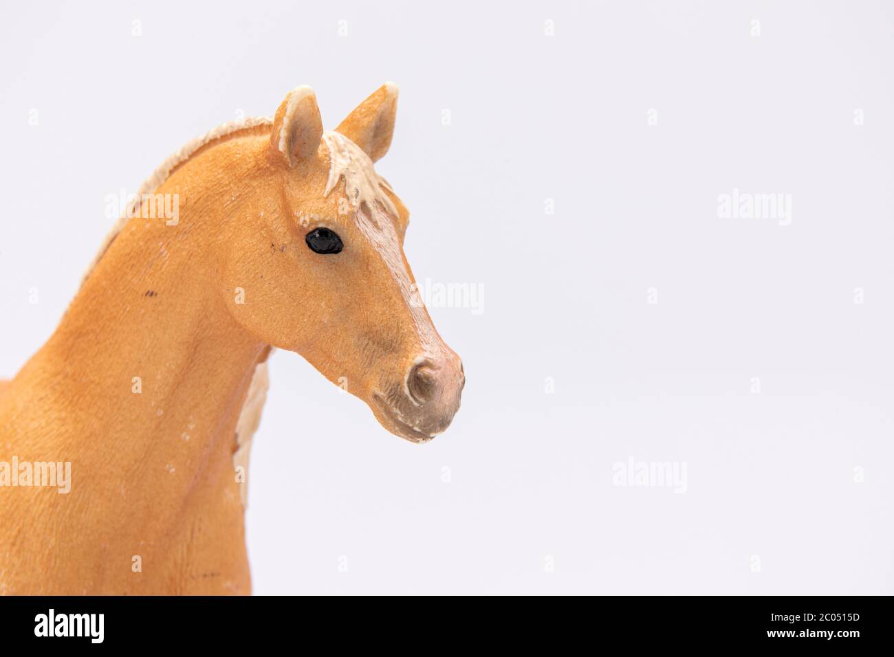 gros plan d'une tête de cheval en plastique marron isolée sur un fond blanc Banque D'Images