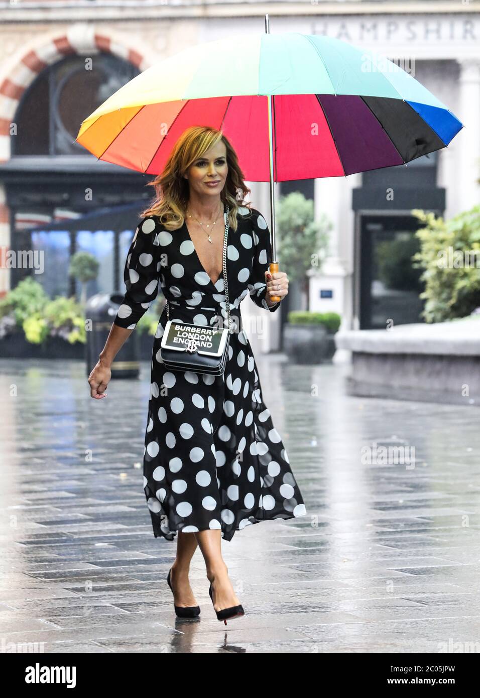 Amanda Holden a vu tenir un parapluie au départ des studios de radio Global à Londres. Banque D'Images