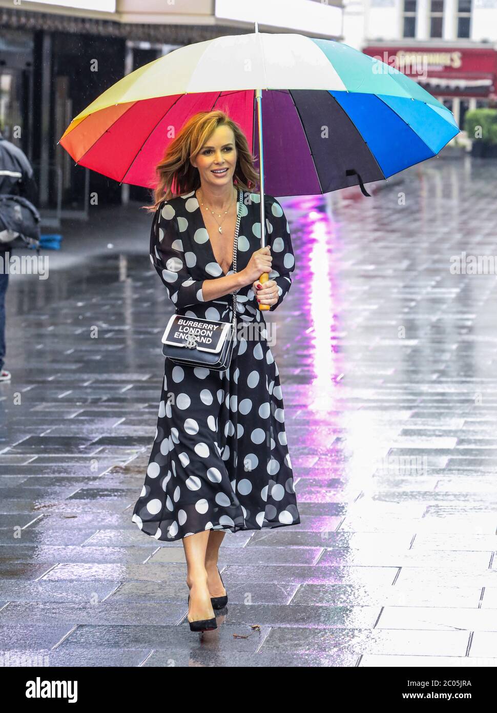 Amanda Holden a vu tenir un parapluie au départ des studios de radio Global à Londres. Banque D'Images